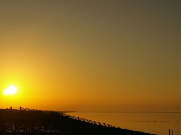 Zonsondergang boven de dijk